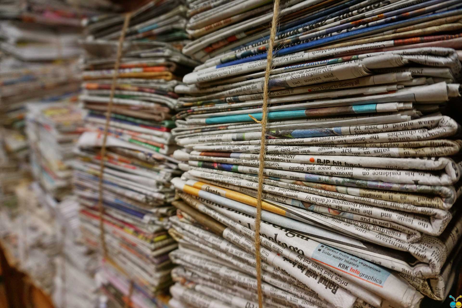 stack of newspapers tightly bound by a rope