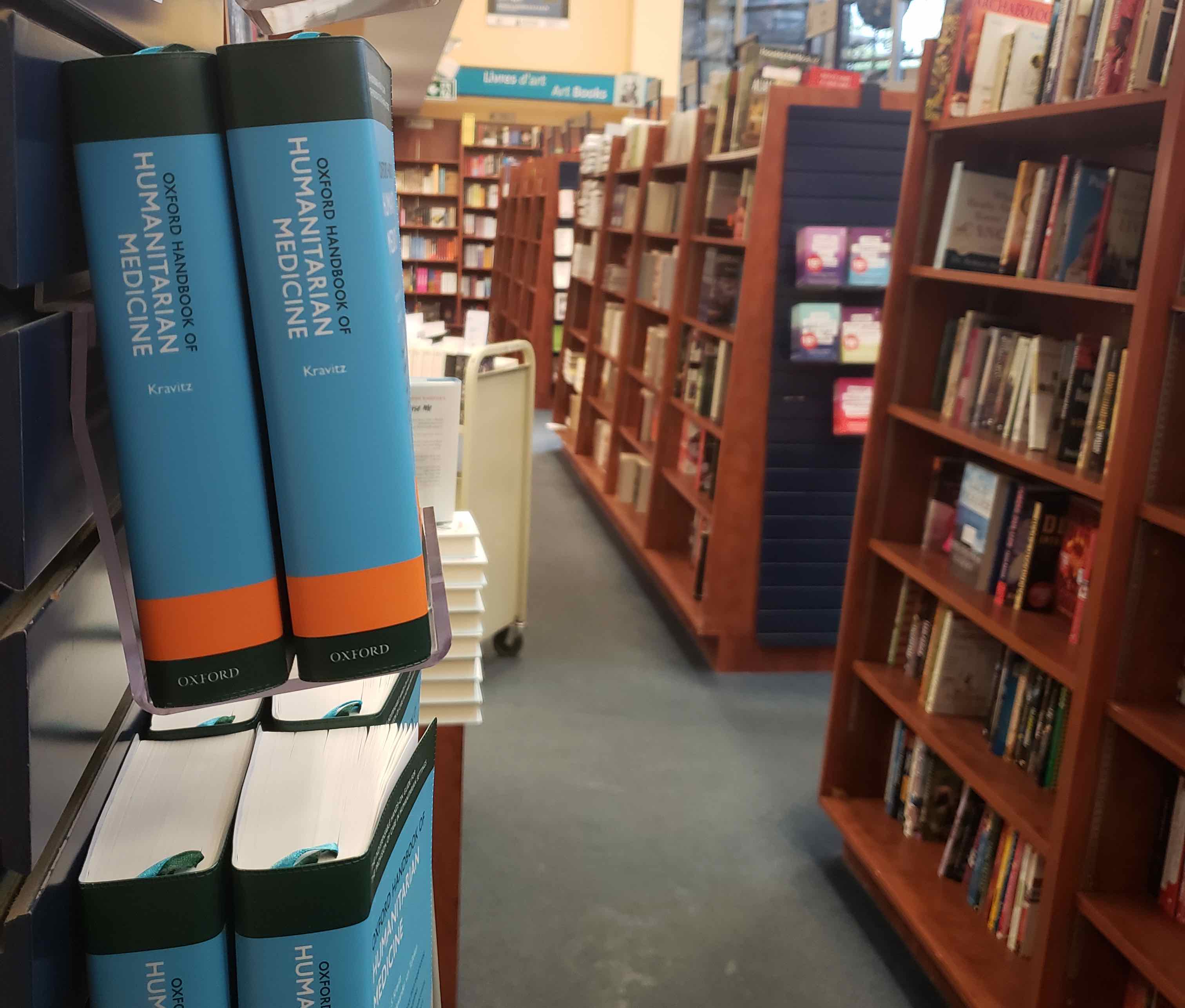 Copies of Oxford Handbook of Humanitarian Medicine displayed in a bookstore