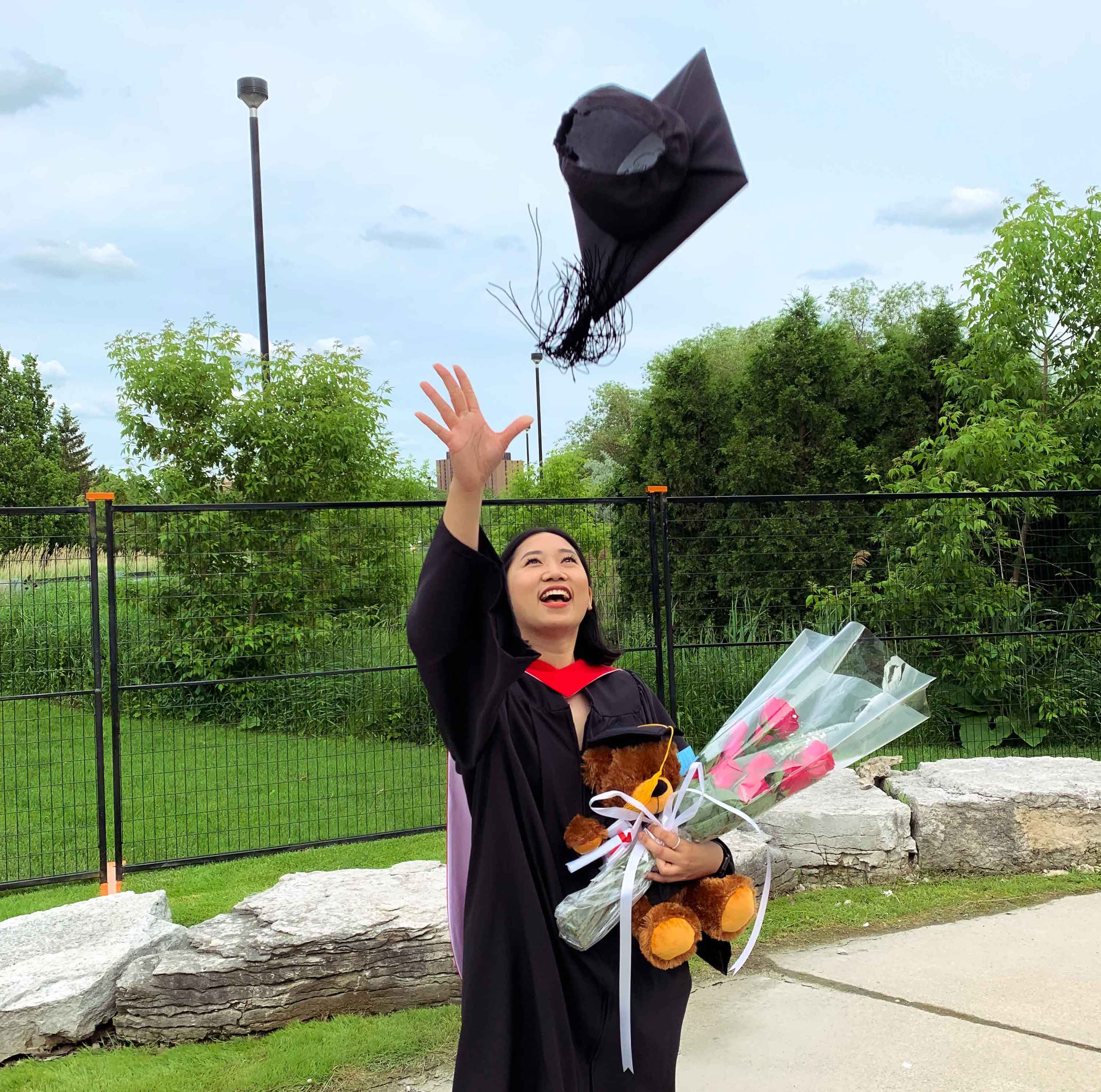 A Dahdaleh Institute intern who graduated throws her hat into the air